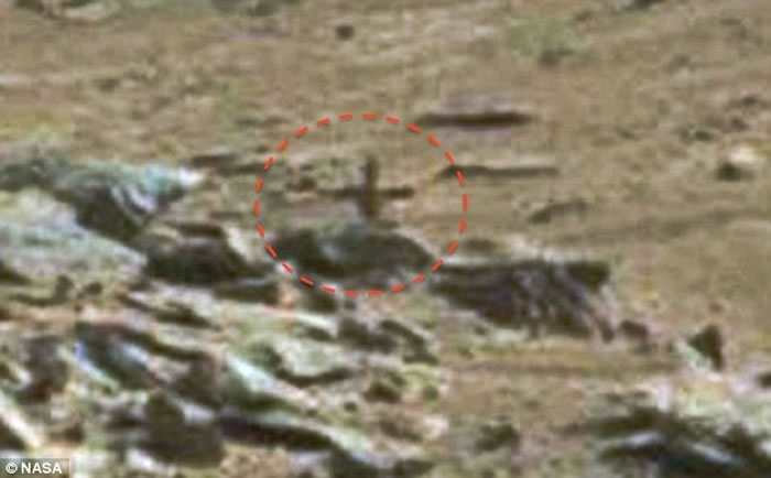 UFO猎人在火星表面获得了新发现，岩石中半掩着一个十字架结构，令人们联想到火星表面潜在着某种宗教活动。